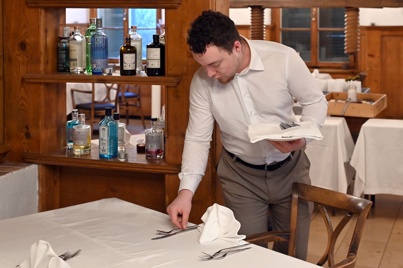 Un employé dresse la table au restaurant Liebefeld.